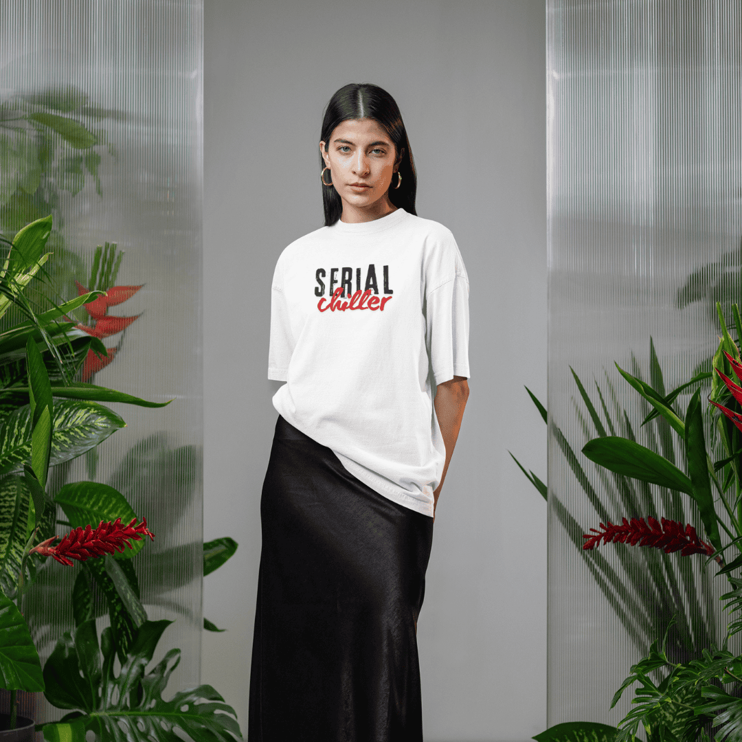 Person wearing a white t-shirt with 'Serial Chiller' text, standing in front of plants. wordsarmor