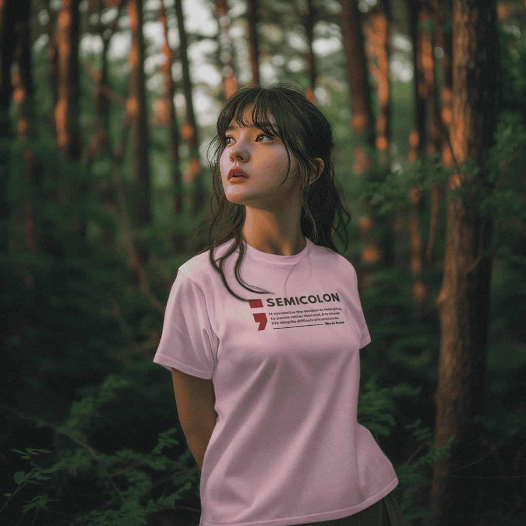 Person wearing a baby pink t-shirt with 'SEMICOLON' design in a forest setting wordsarmor