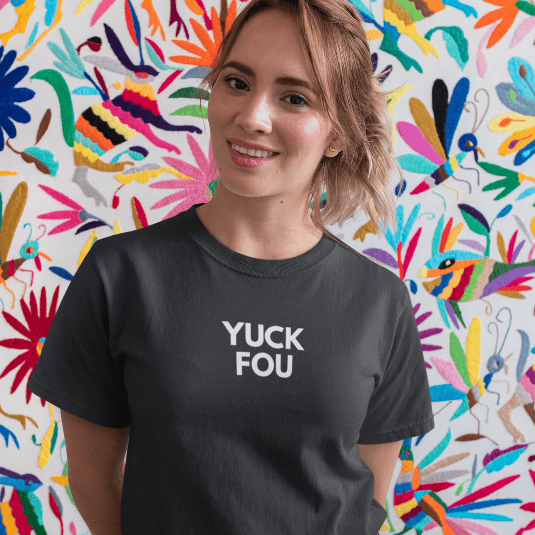 Person wearing a black t-shirt with 'YUCK FOU' text in front of a colorful abstract wall wordsarmor.