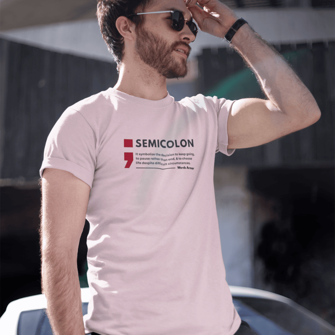 Man wearing a peach t-shirt with a semicolon design and text. wordsarmor