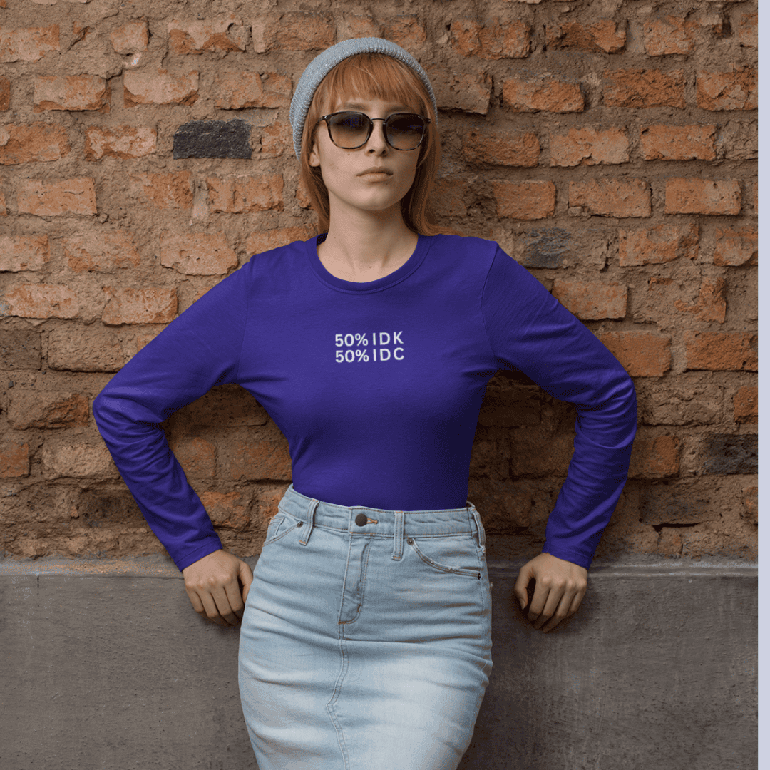 Person wearing a blue long-sleeve shirt with text and light blue jeans against a brick wall wordsarmor