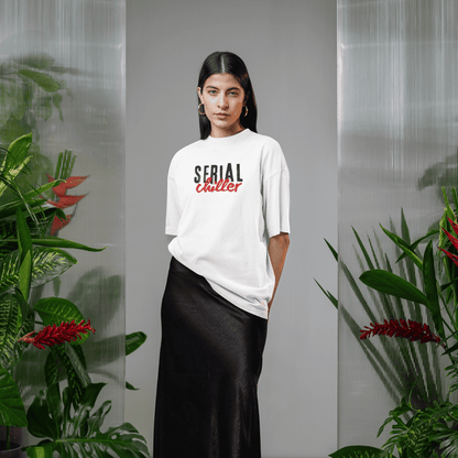 Person wearing a white t-shirt with 'Serial Chiller' text, standing in front of plants. wordsarmor