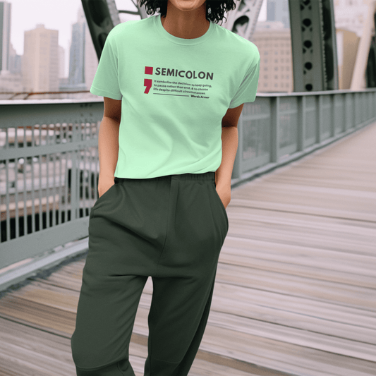 Person wearing a jade green t-shirt with a semicolon message on it, standing on a bridge. wordsarmor