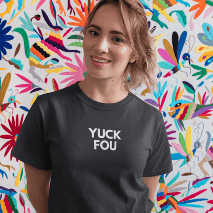 Person wearing a black t-shirt with 'YUCK FOU' text in front of a colorful abstract wall wordsarmor.
